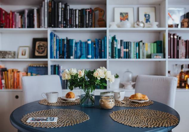 kaboompics_Round breakfast table with white flowers by the bookcase